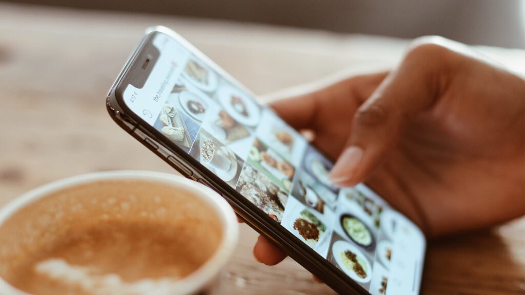 Osoba używająca iPhone'a przy kawie – Focus Mode tryb skupienia