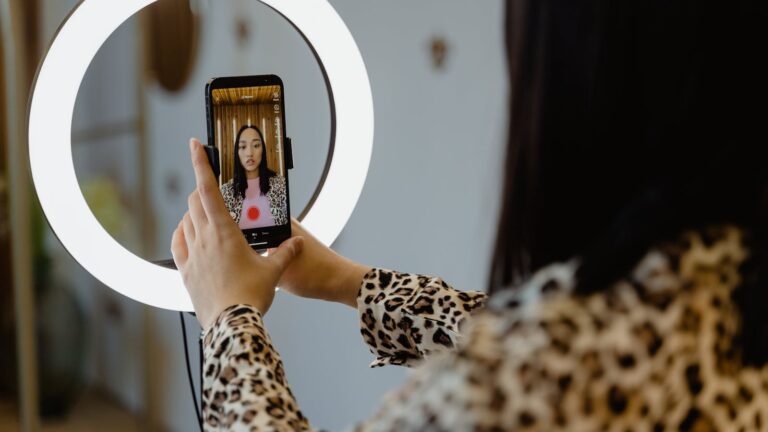 Kobieta tworzy treści ze smartfonem i ring light — AI do tworzenia contentu na Instagram
